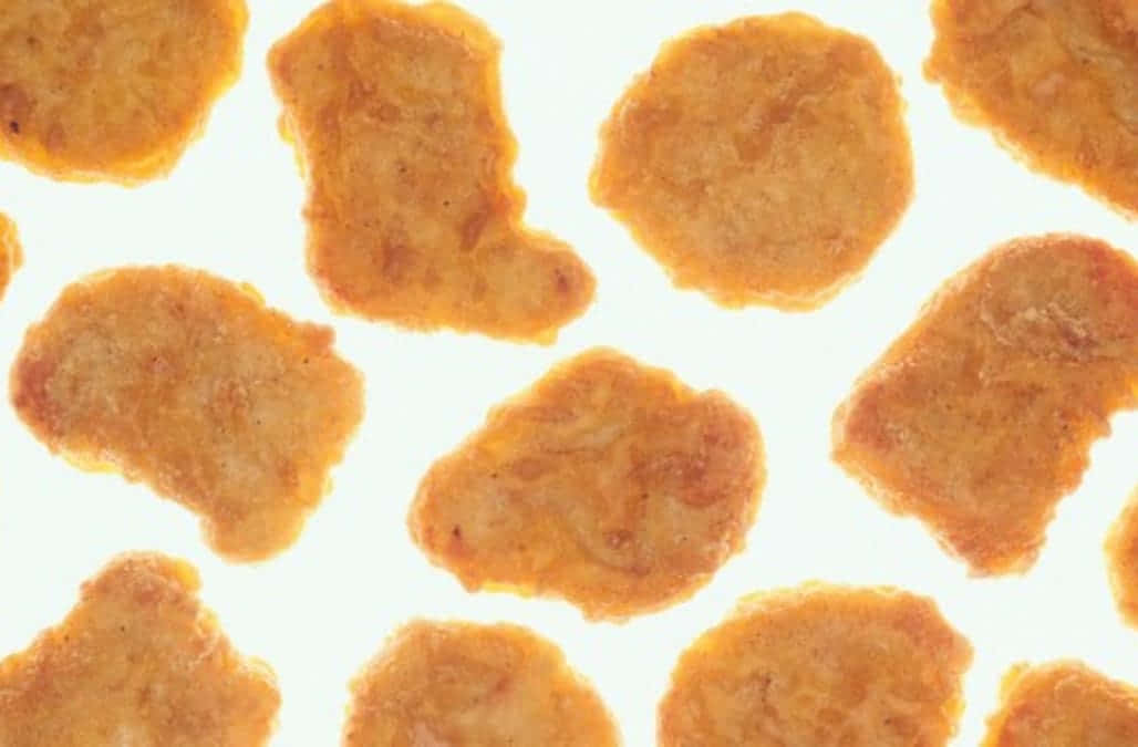 A Mouth-watering Plate Of Golden-brown Chicken Nuggets Wallpaper