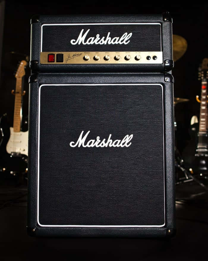 A Musician Plays An Electric Guitar With A Classic Tube Amplifier Wallpaper