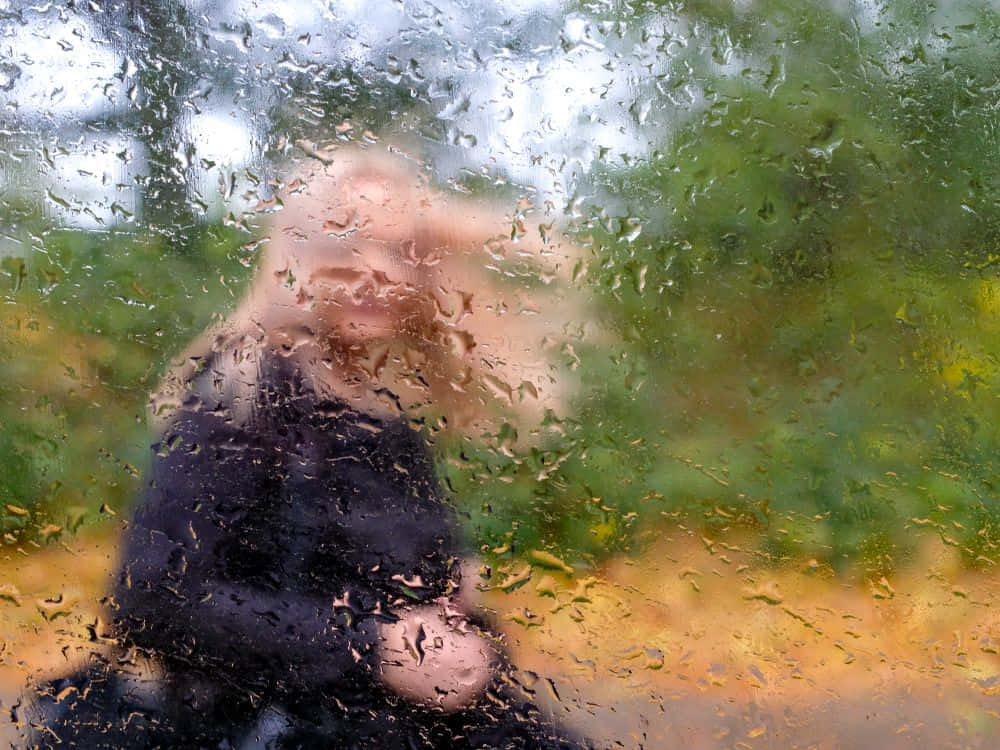 A Mysterious Figure Behind A Wet Glass Wallpaper