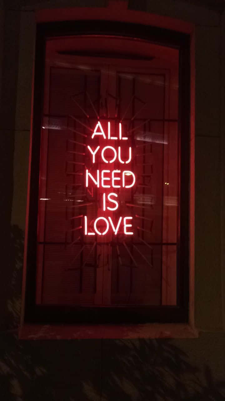 A Neon Sign That Says All You Need Is Love Wallpaper