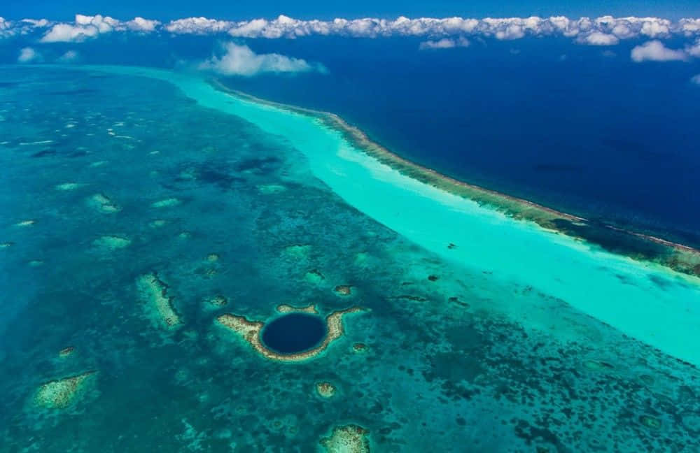 A Paradisiac Aerial View Of The Blue Hole In Belize Wallpaper