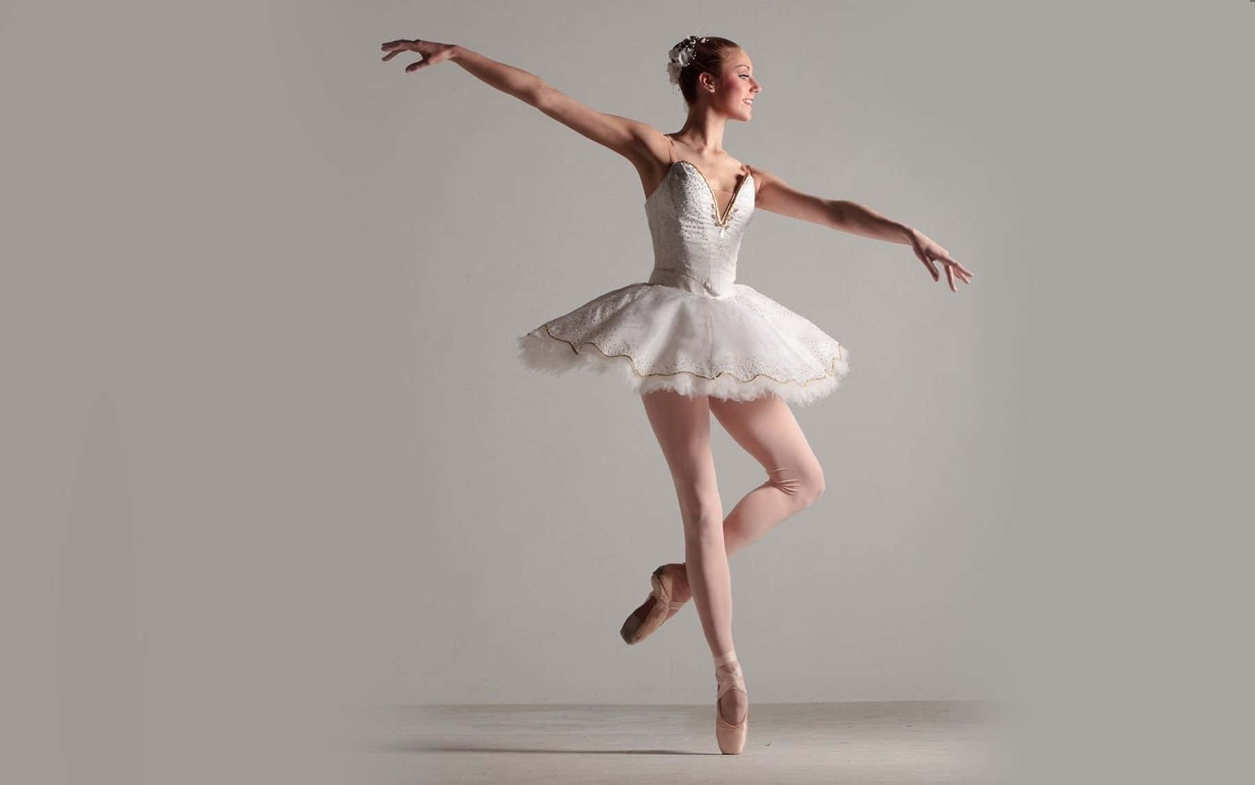 A Passionate Ballerina Wearing Pink Pointe Shoes. Wallpaper