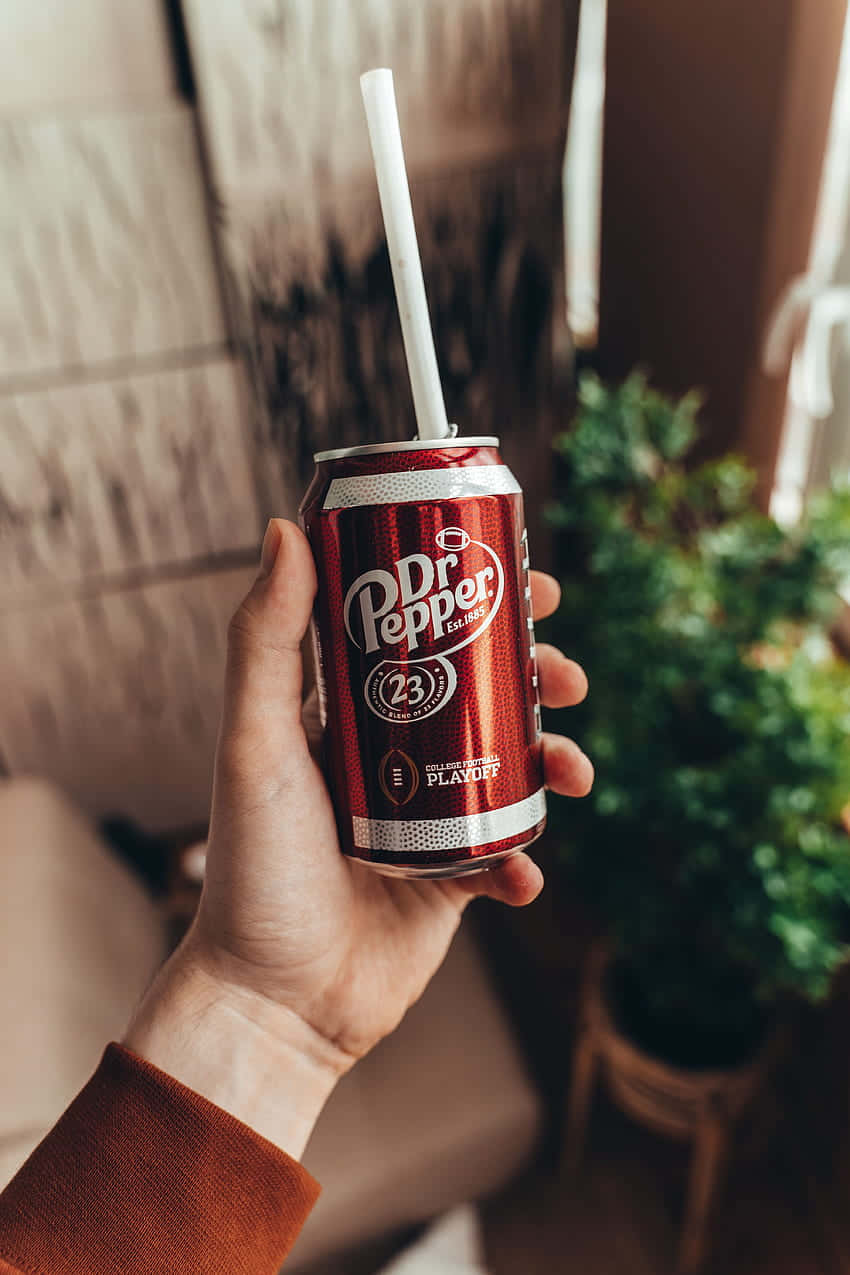 A Person Holding A Can Of Pepsi With A Straw Wallpaper