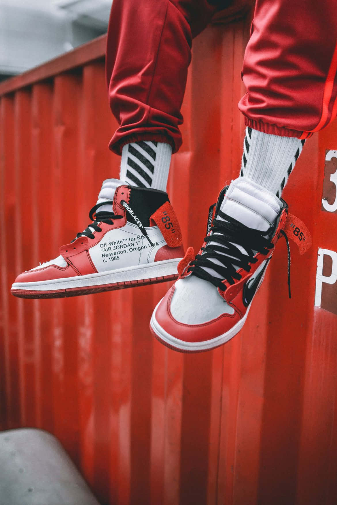 A Person Is Leaning On A Red Container Wallpaper