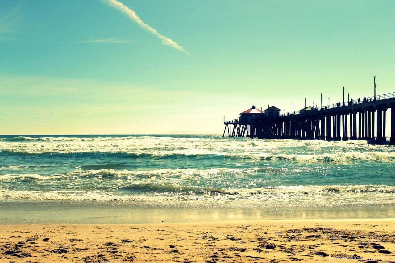 A Pier With A Car On The Beach Wallpaper