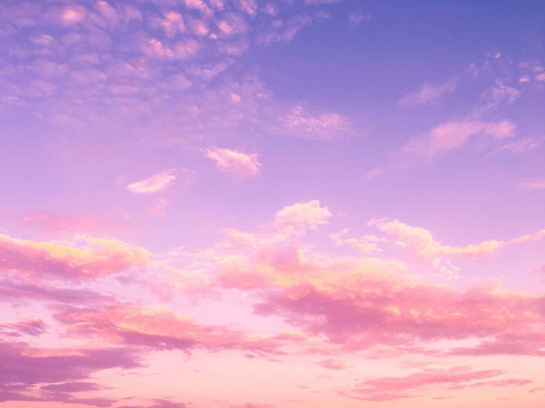 A Pink And Purple Sky With Clouds Wallpaper