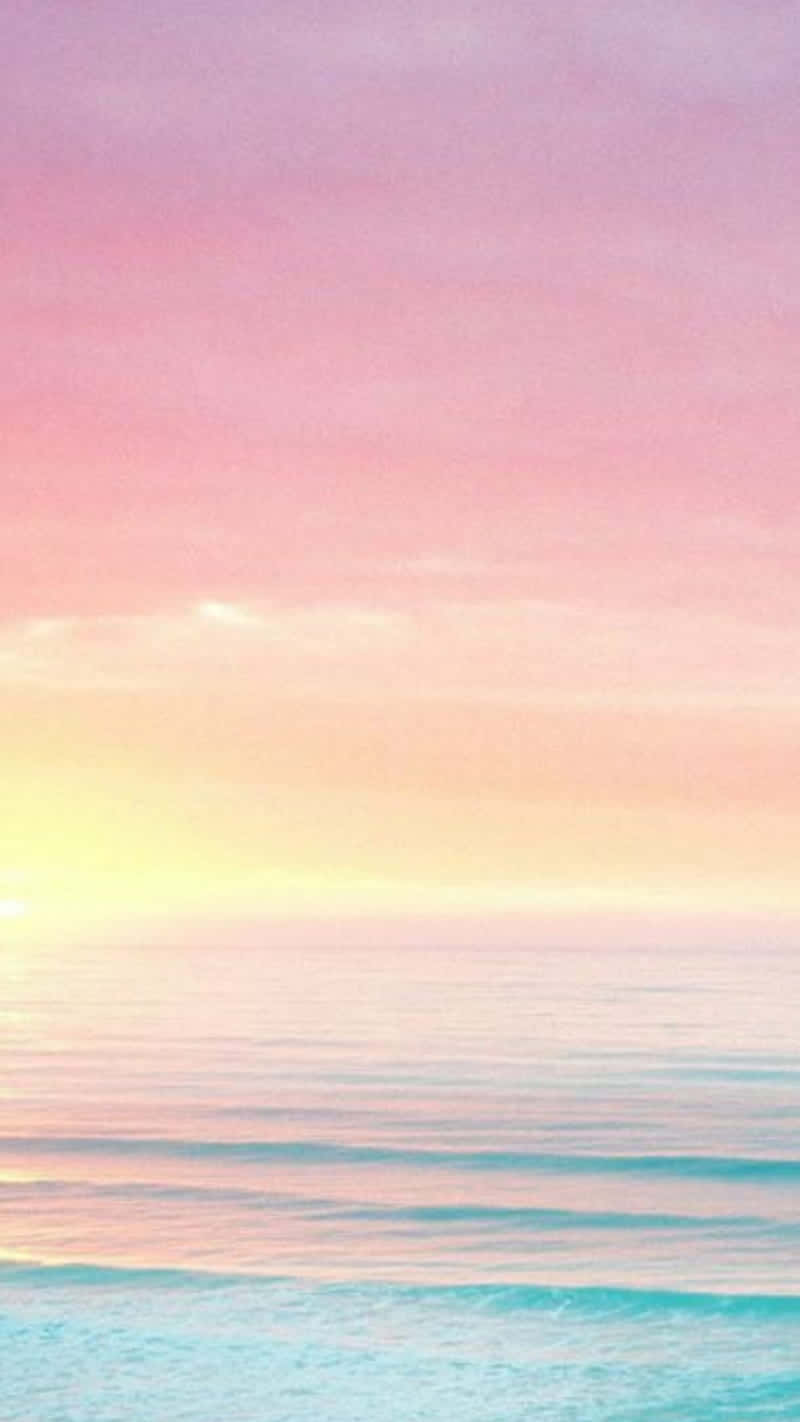 A Pink And Purple Sunset Over The Ocean Wallpaper