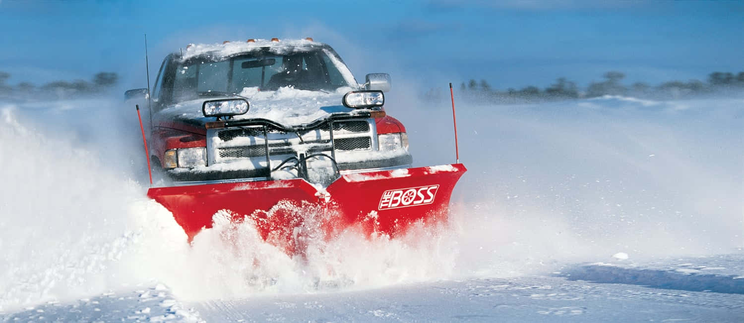 A Powerful Snowplow In Action Clearing A Snowy Road Wallpaper