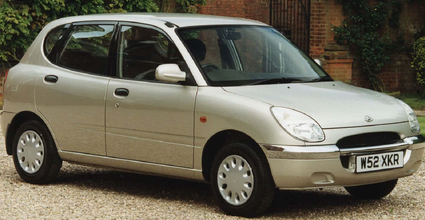 A Pristine Daihatsu Sirion Parked Under A Clear Blue Sky Wallpaper