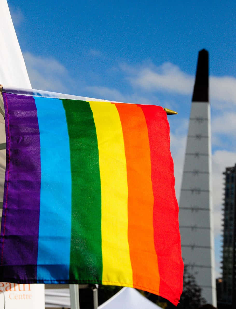 A Rainbow Flag Hanging From A Building Wallpaper