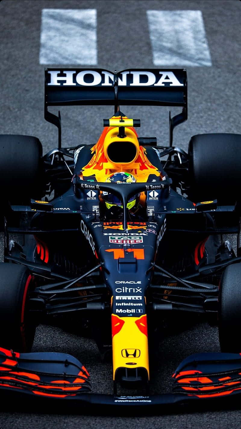 A Red Bull Racing Car Is Driving On A Track Wallpaper