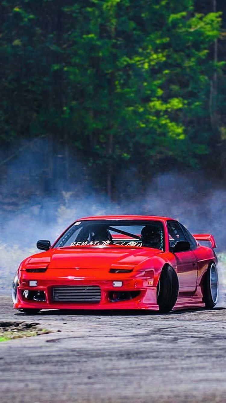 A Red Drift Car Driving Down A Track Wallpaper