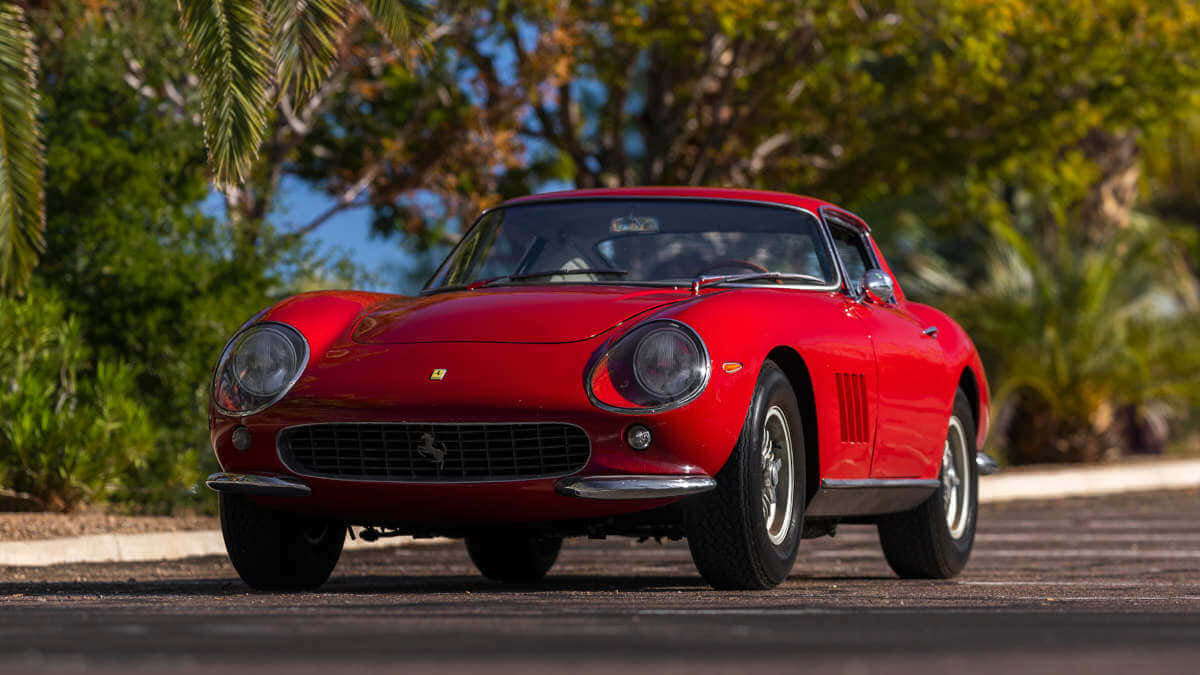 A Red Ferrari Sports Car Is Parked In The Street Wallpaper