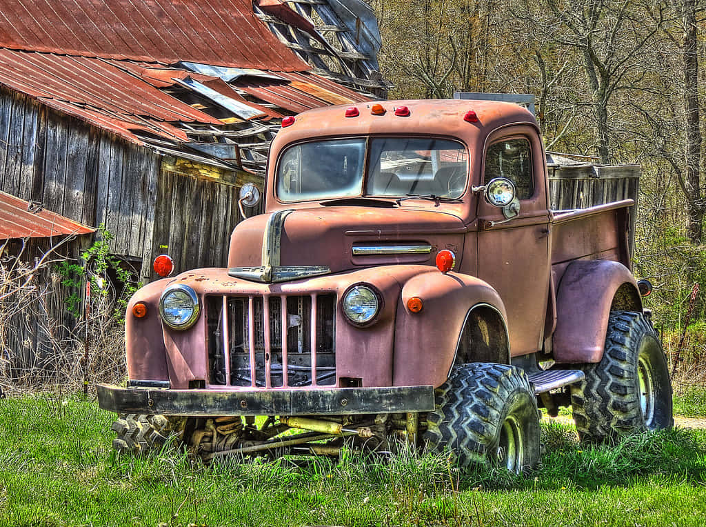 A Red Truck Parked In The Grass Wallpaper