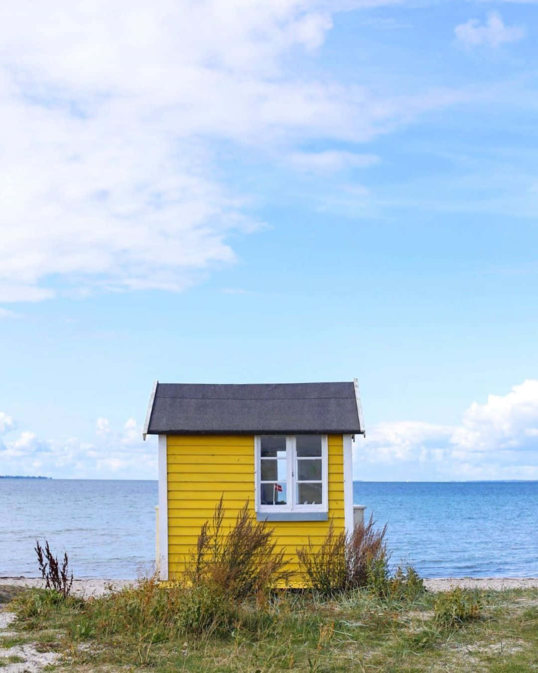 A Row Of Colorful Beach Huts Along The Shore Wallpaper