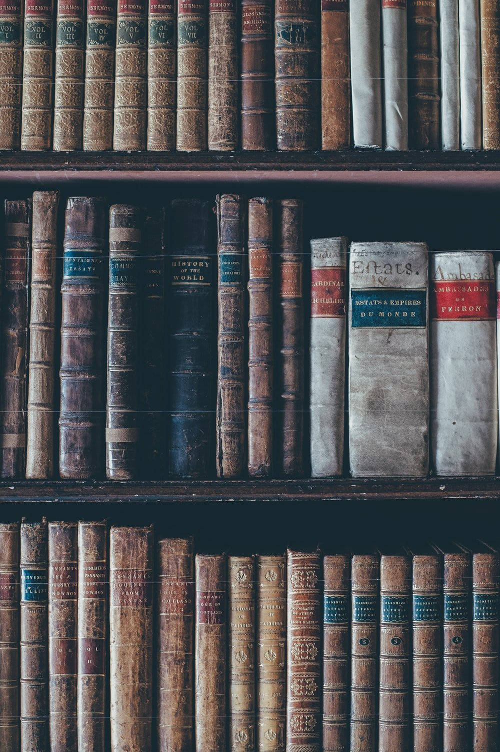 A Row Of Old Books On A Shelf Wallpaper