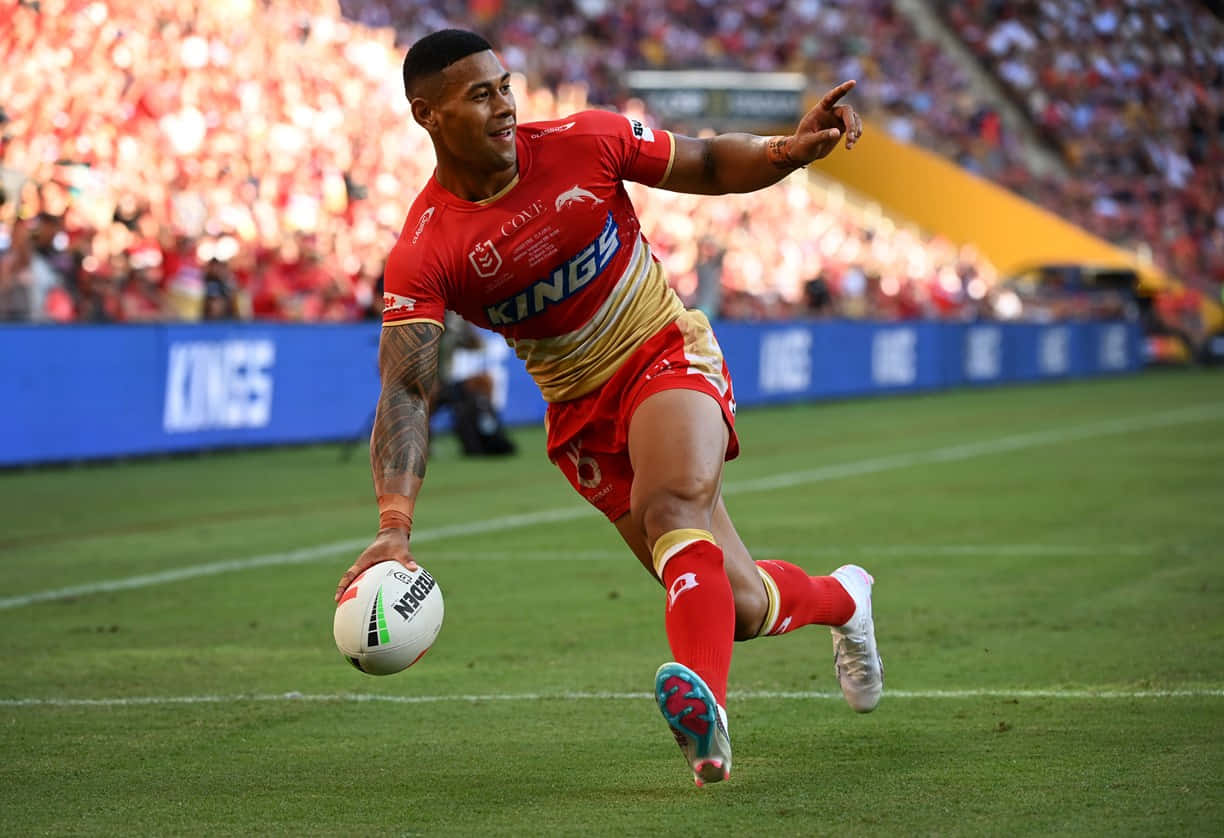 A Rugby Player Kicking The Ball In Front Of A Crowd Wallpaper