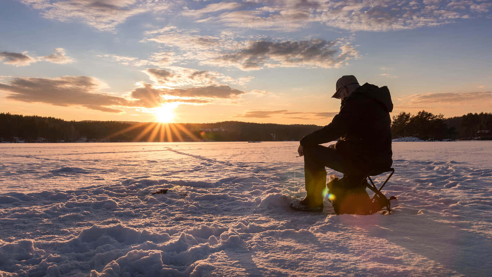 A Serene Ice Fishing Setup On A Frozen Lake Wallpaper