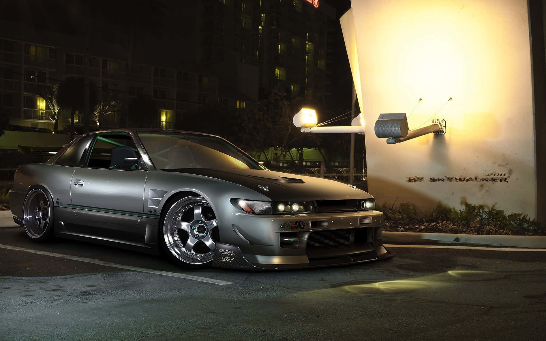 A Silver Car Parked In Front Of A Building At Night Wallpaper