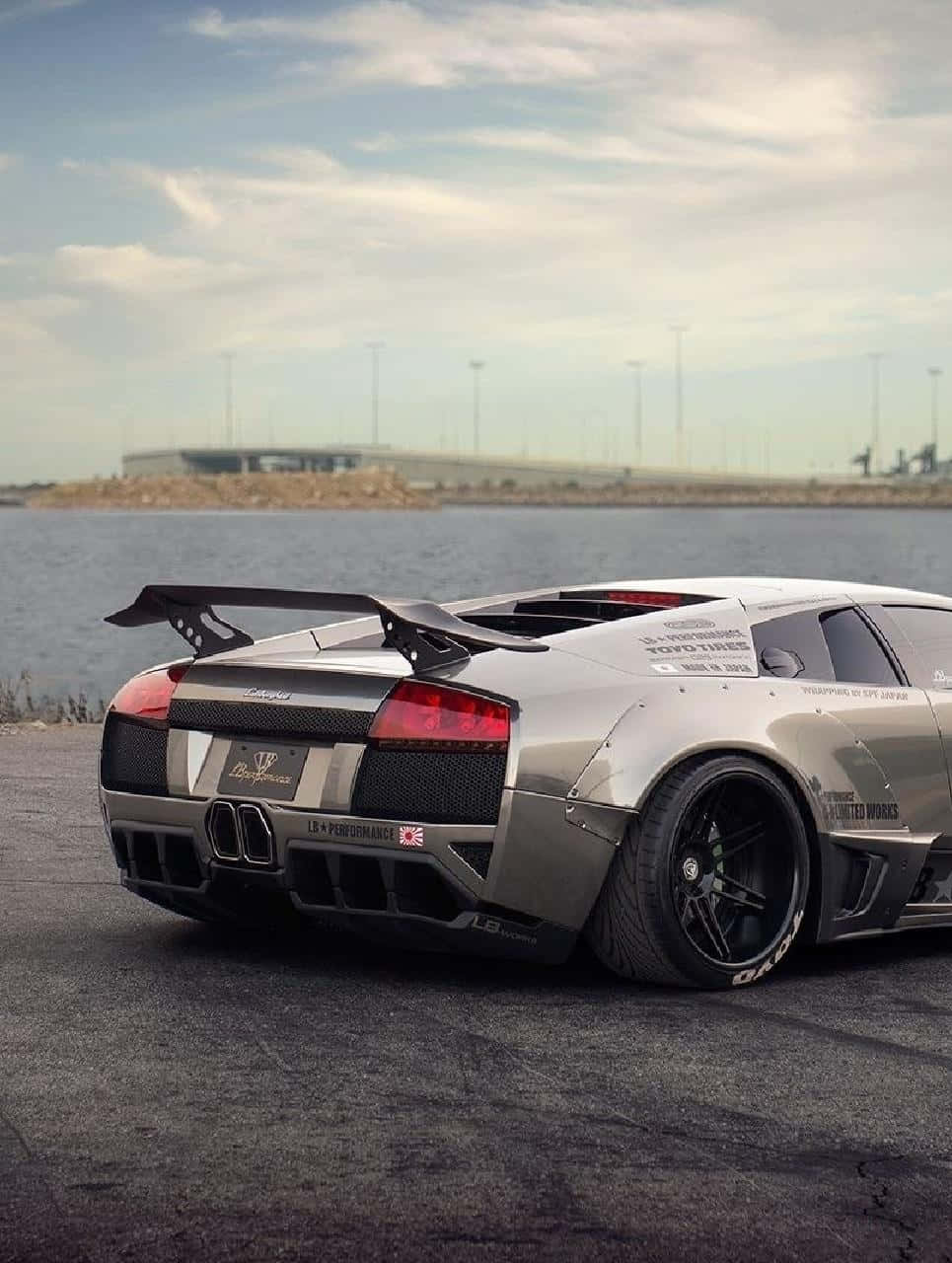 A Silver Sports Car Parked On The Side Of The Road Wallpaper