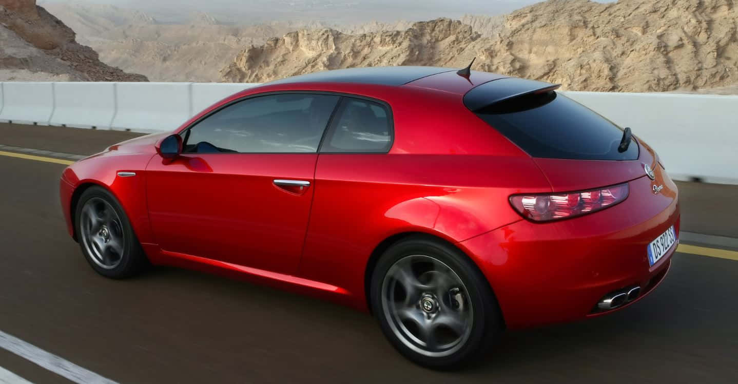 A Sleek Alfa Romeo Brera Parked On A City Street Wallpaper