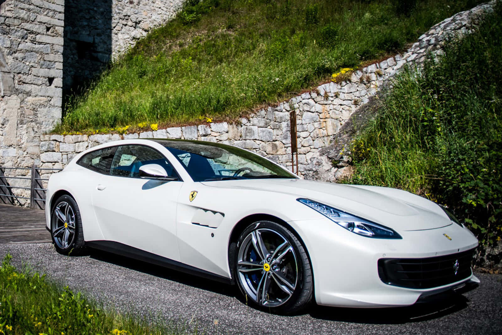 A Sleek And Stunning Ferrari Gtc4lusso In Motion On A Scenic Road Wallpaper