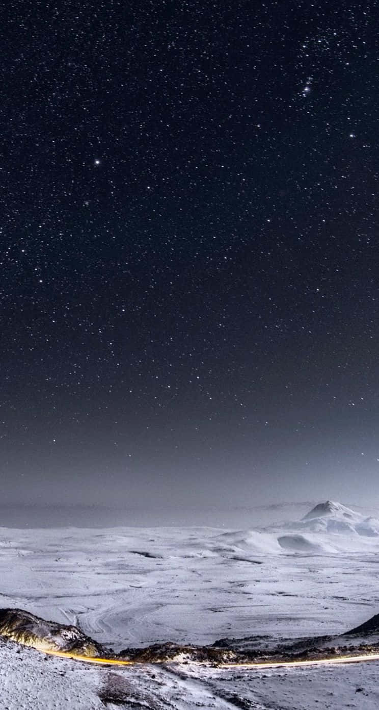 A Snowy Landscape With Stars And A Road Wallpaper