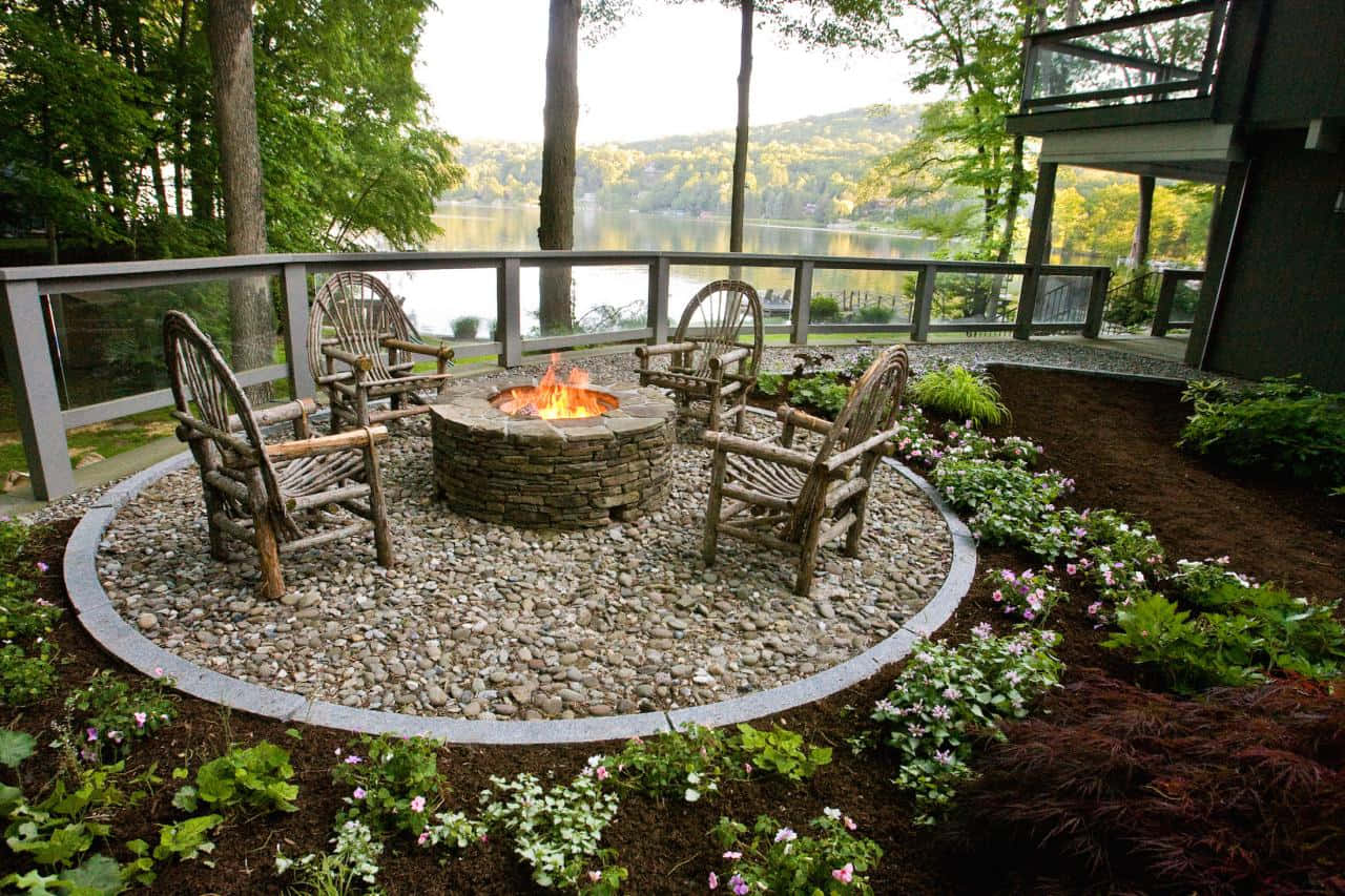 A Stunning Garden Design Featuring A Waterfall And Wooden Bridge Wallpaper