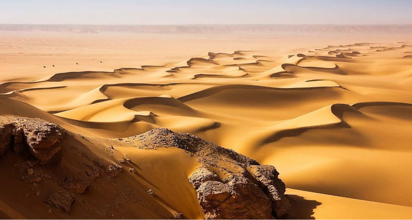 A Stunning View Of Sand Dunes At Sunset Wallpaper