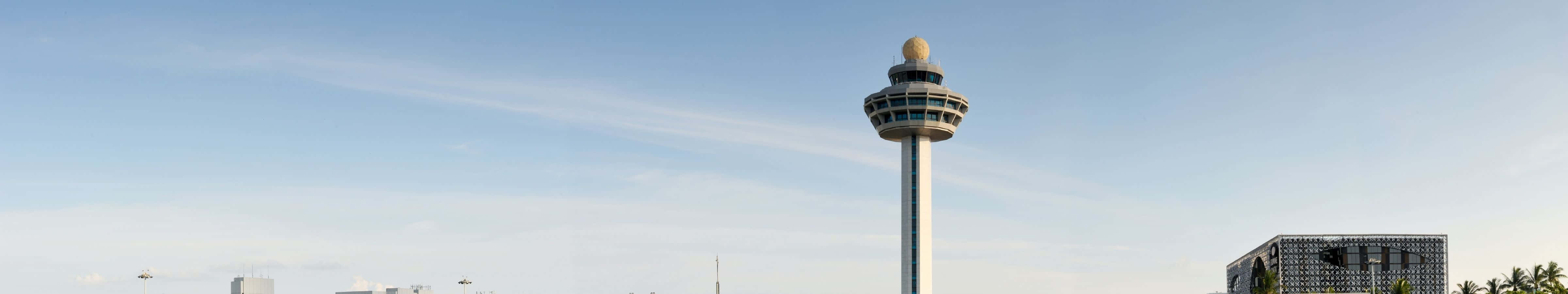 A Tall Tower With A Large Building In The Background Wallpaper