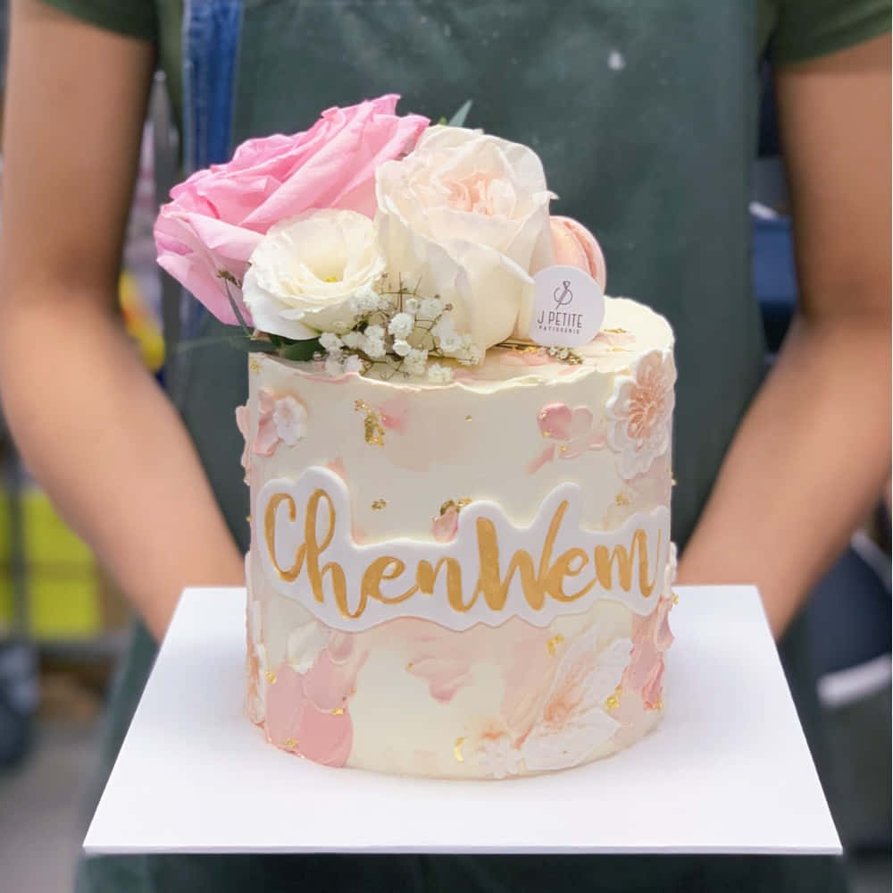 A Three-tier White And Pink Cake Covered In Fondant Wallpaper