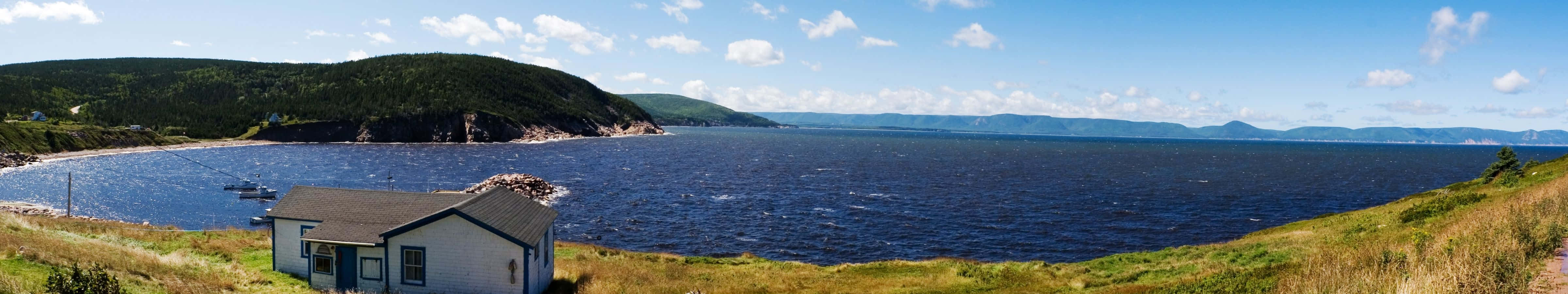 A View Of A House On A Hill Overlooking The Ocean Wallpaper