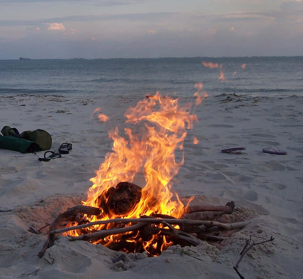 A Warm Beach Campfire At Sunset Wallpaper