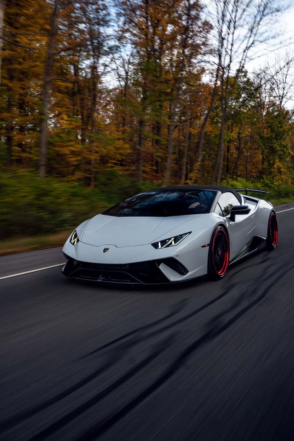 A White Sports Car Driving Down A Road Wallpaper