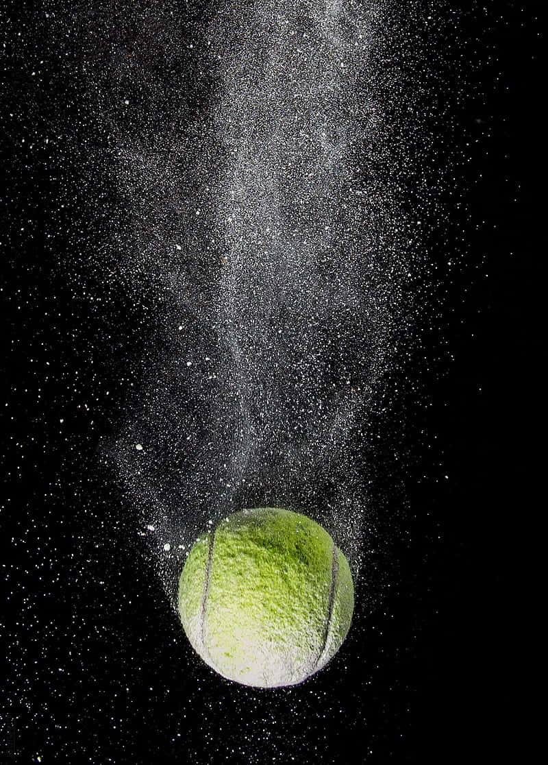 A White Tennis Ball Resting Against An Off-white Grass Surface Wallpaper