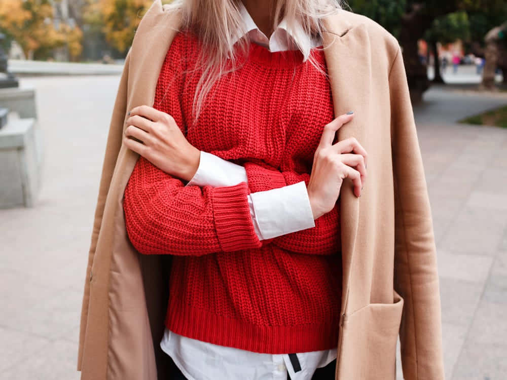 A Woman Wearing A Cozy Red Sweater Perfect For Autumn And Winter. Wallpaper