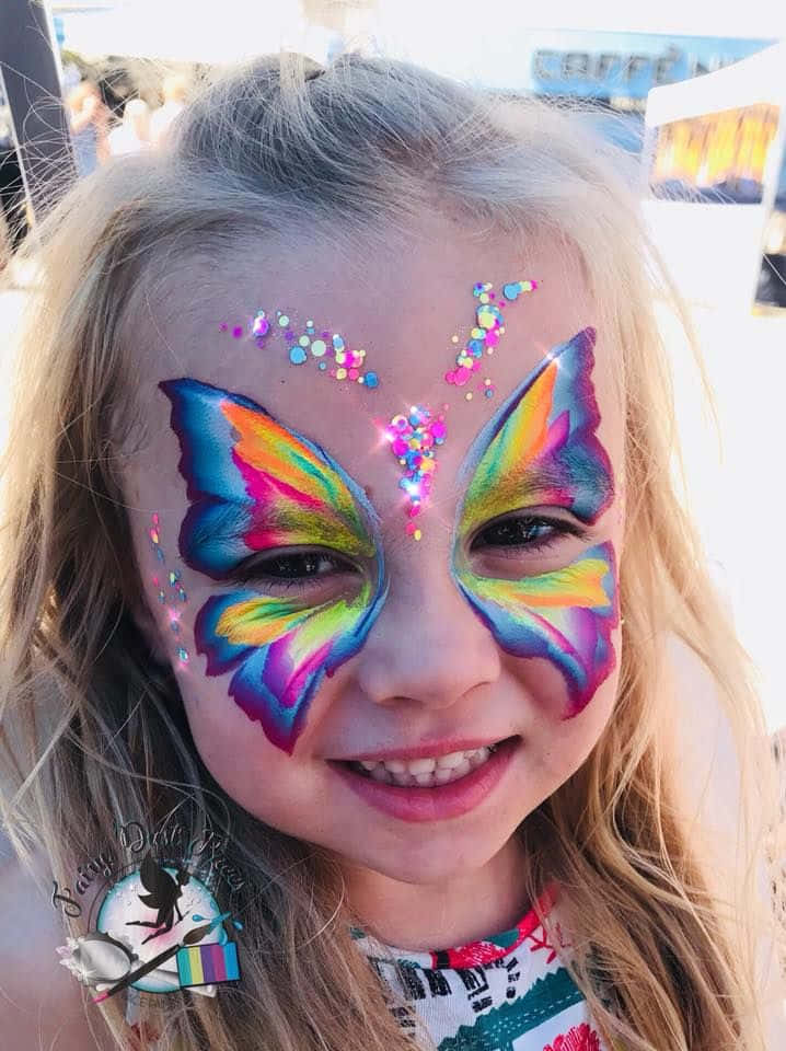 A Woman With A Colorful, Intricate Butterfly Face Painting. Wallpaper