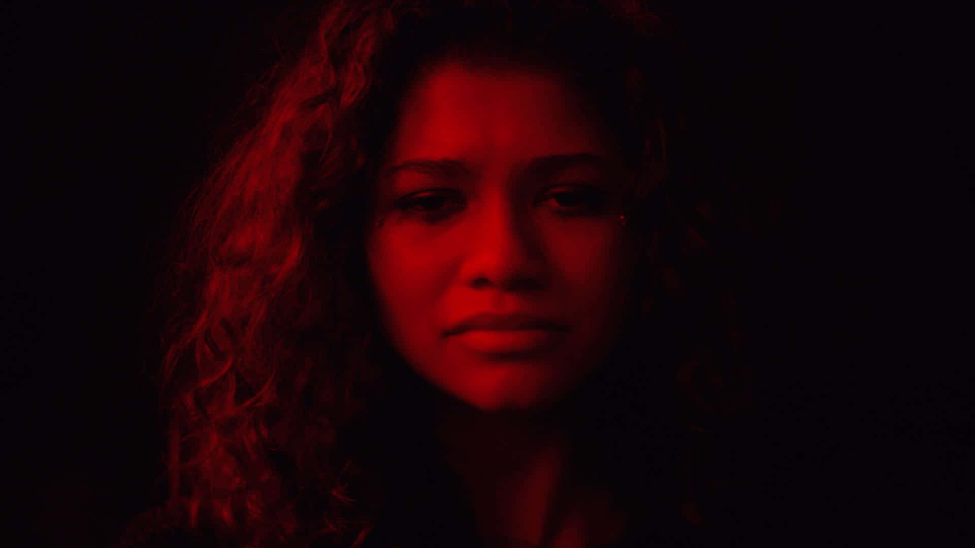 A Woman With Curly Hair In A Dark Room Wallpaper