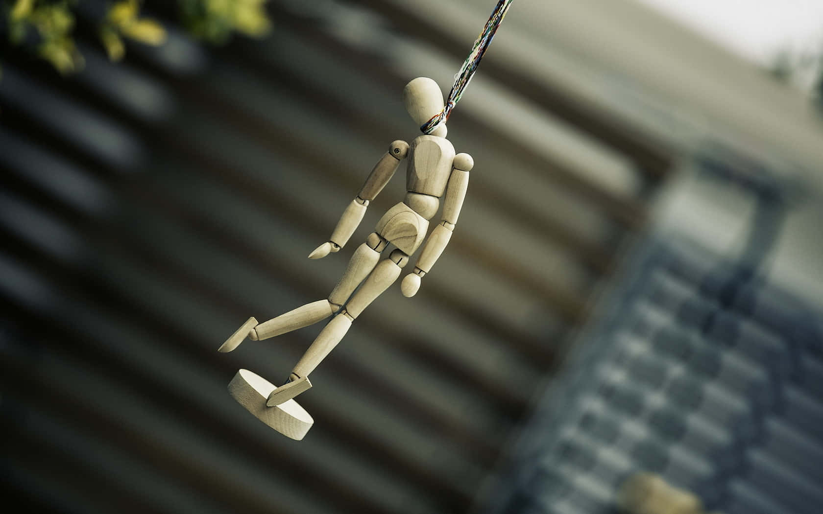 A Wooden Mannequin Hanging From A String Wallpaper