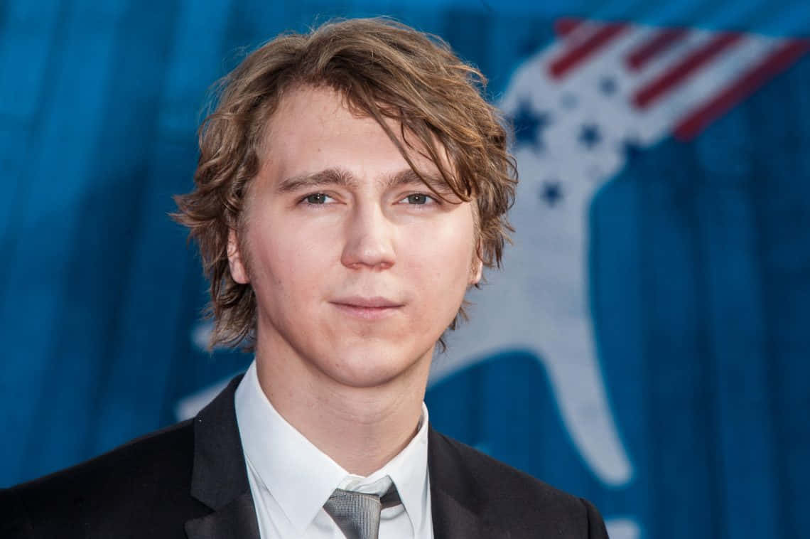 A Young Man In A Suit And Tie Is Posing For A Photo Wallpaper