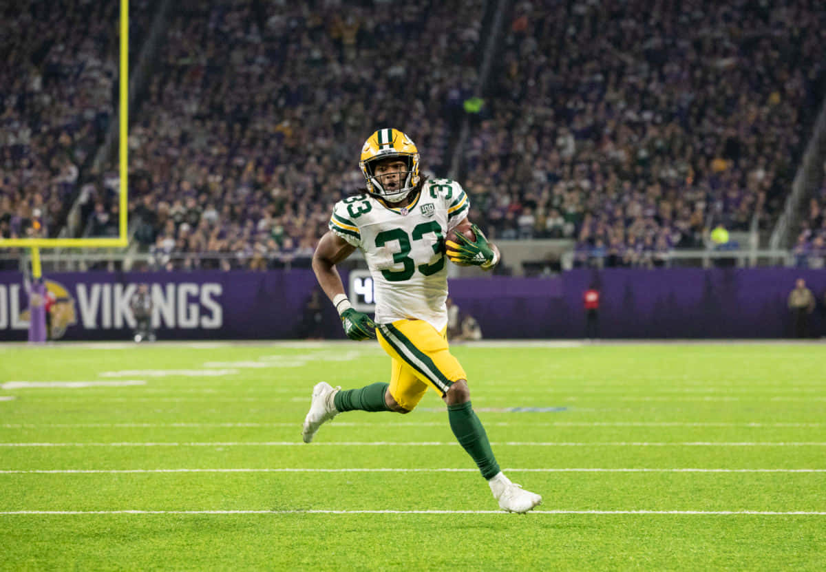 Aaron Jones Racing Down The Football Field Wallpaper