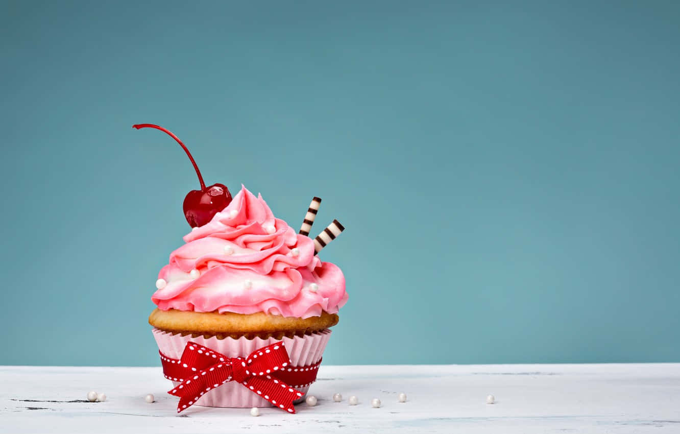 Adorable Pink Frosted Cupcake With Sprinkles Wallpaper