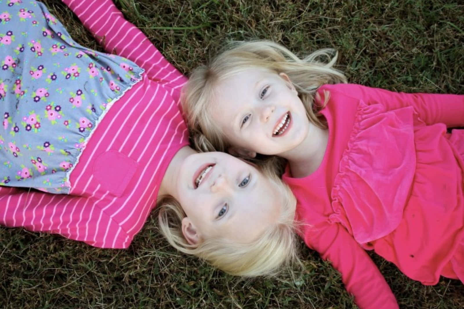 Adorable Toddler Smiling Playfully In A Field Wallpaper