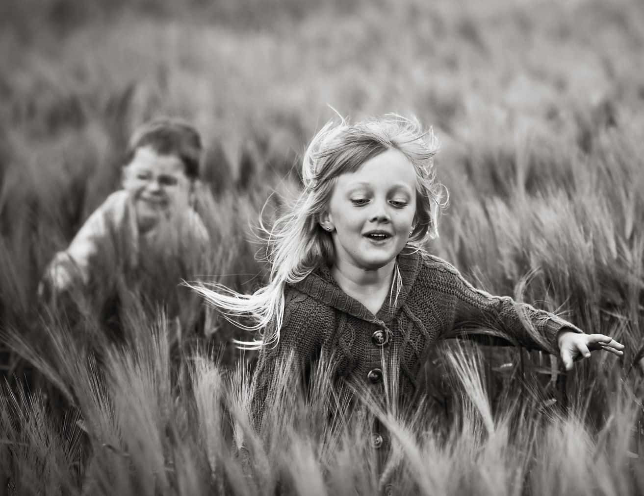 Adorable Toddlers Smiling And Playing Together In A Park Wallpaper