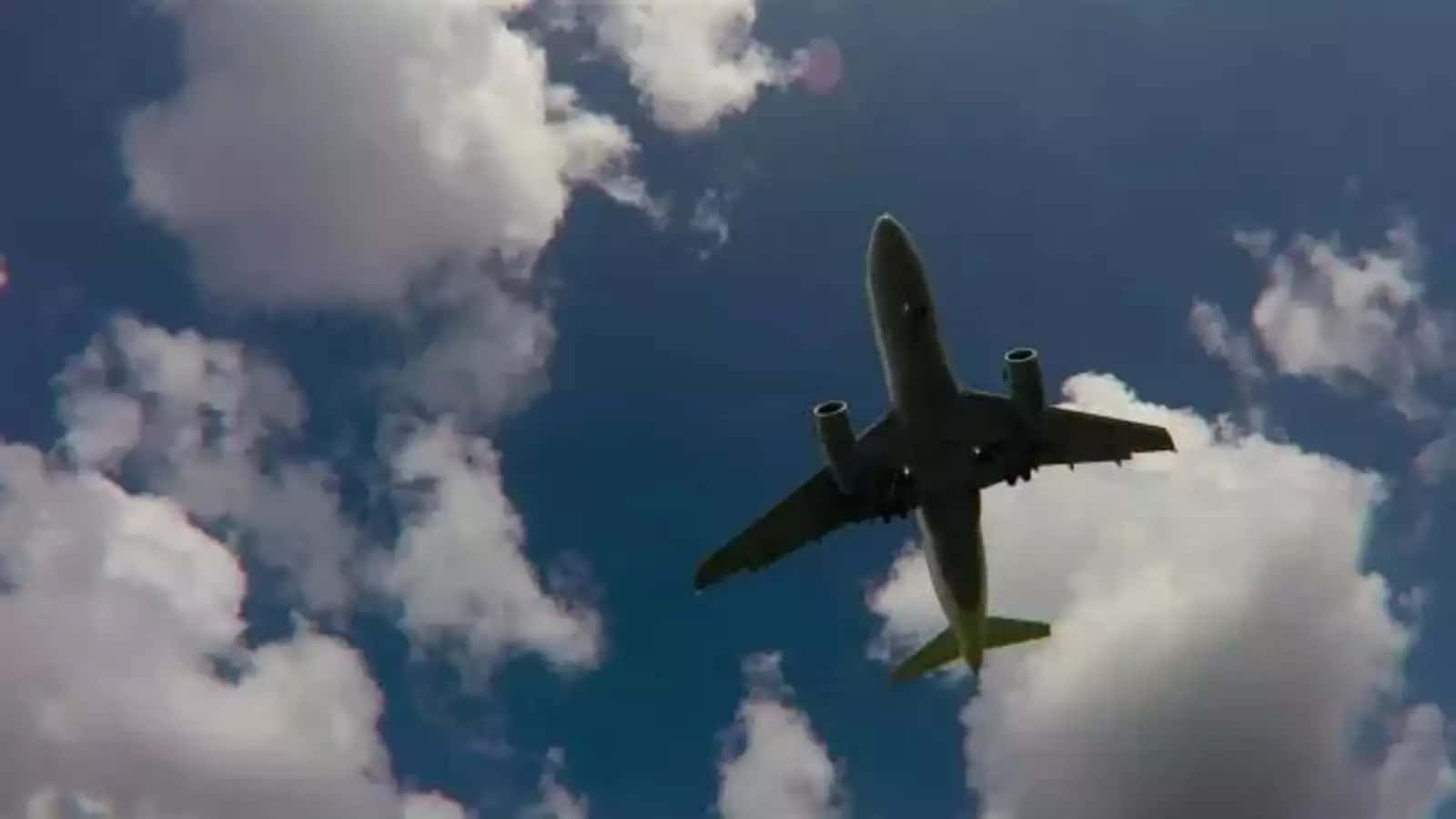 Airplane_ Silhouetted_ Against_ Cloudy_ Sky Wallpaper