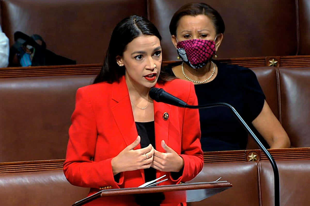 Alexandria Ocasio-cortez In Red Speaking Into Microphone Wallpaper