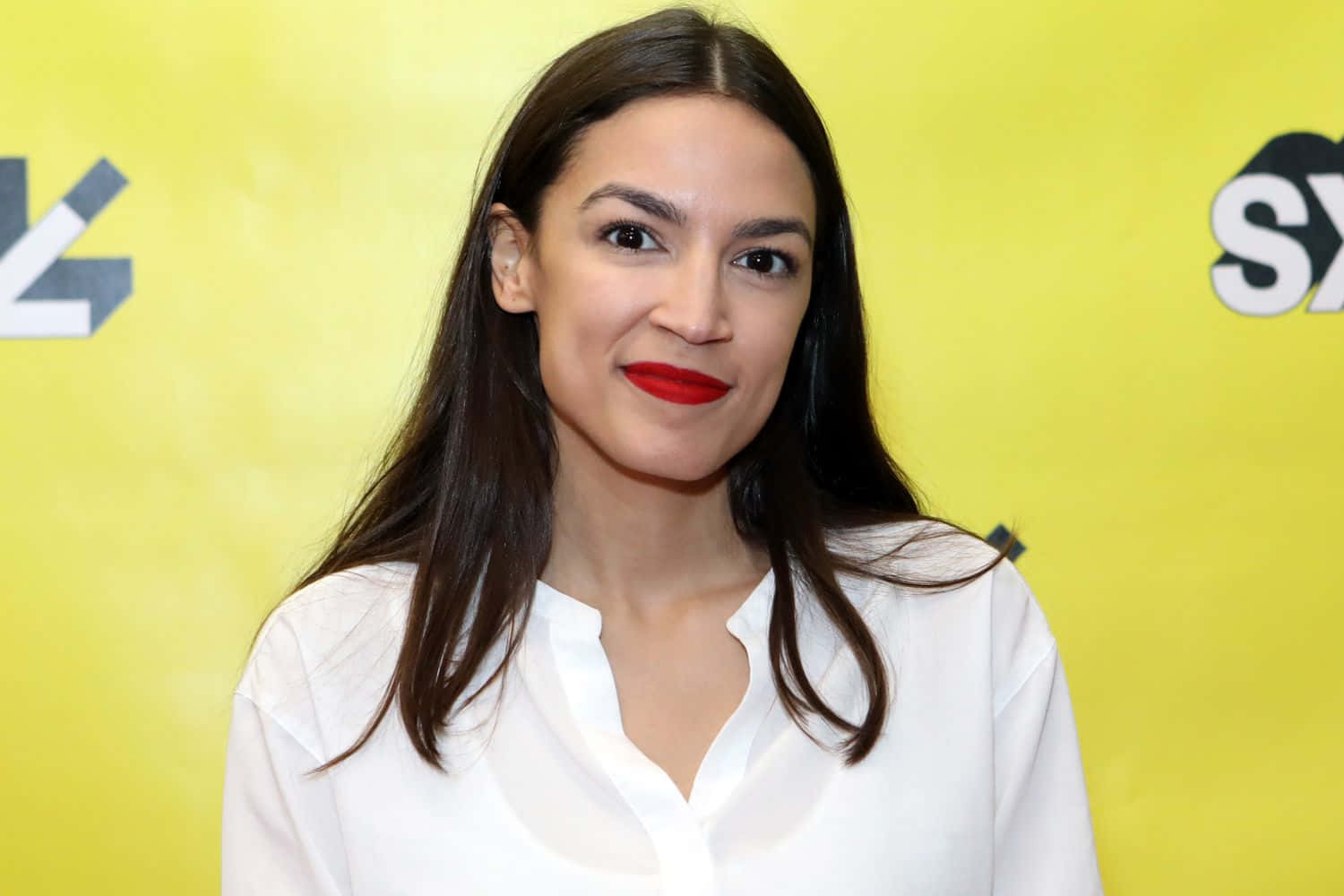 Alexandria Ocasio-cortez, Vibrantly Posed Against A Yellow Backdrop Wallpaper