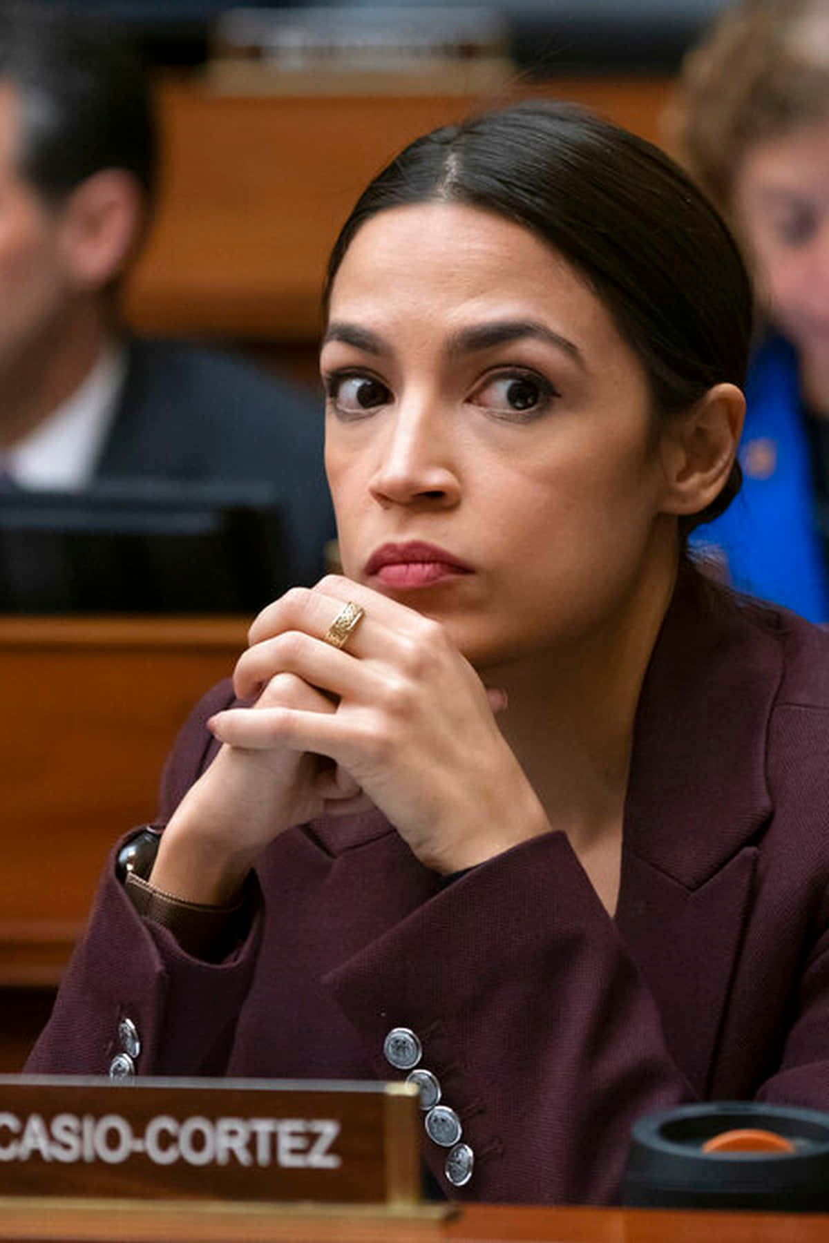 Alexandria Ocasio-cortez With Hands Intertwined Wallpaper