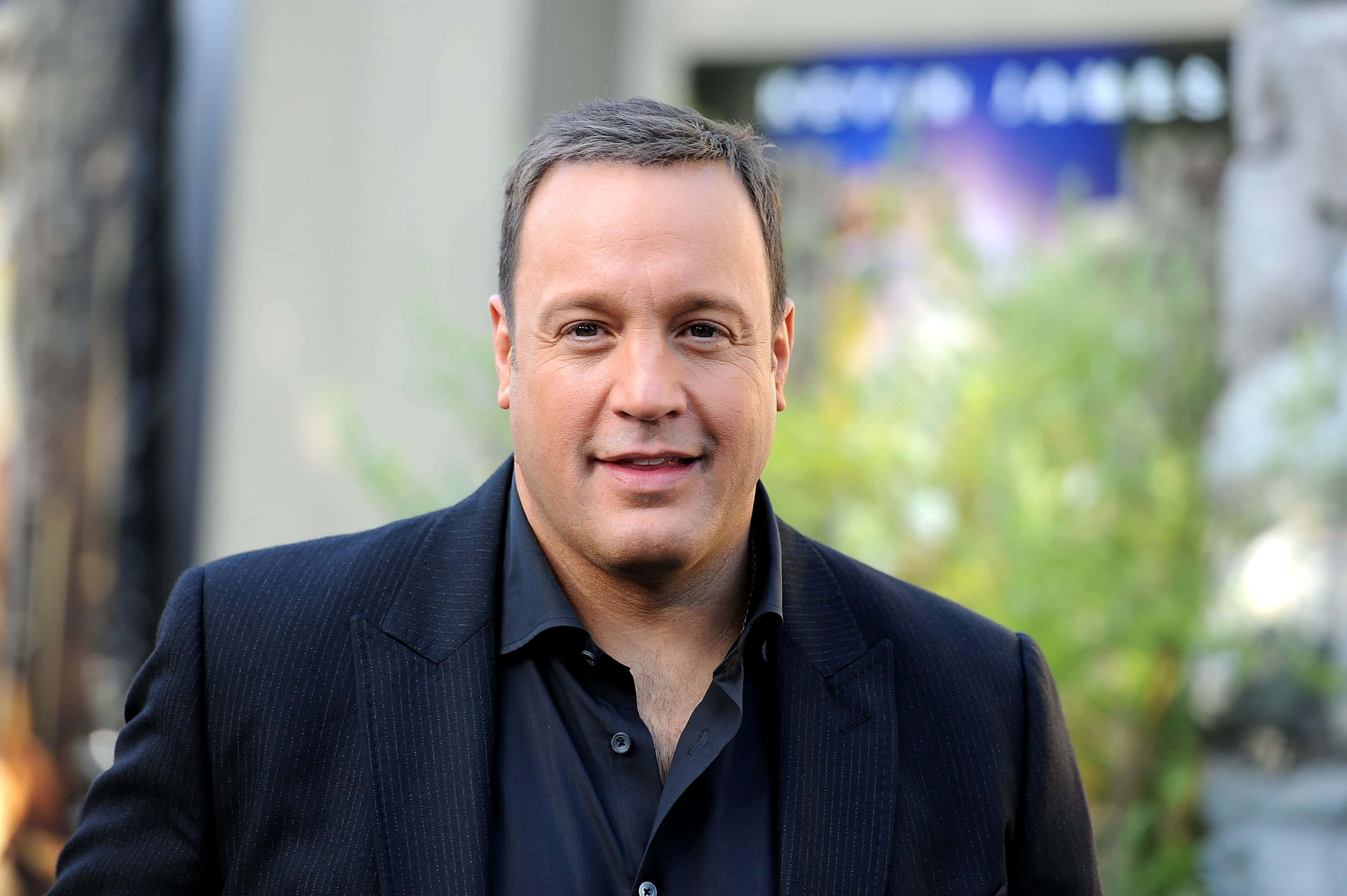 American Comedian Kevin James Exuding Confidence Wallpaper