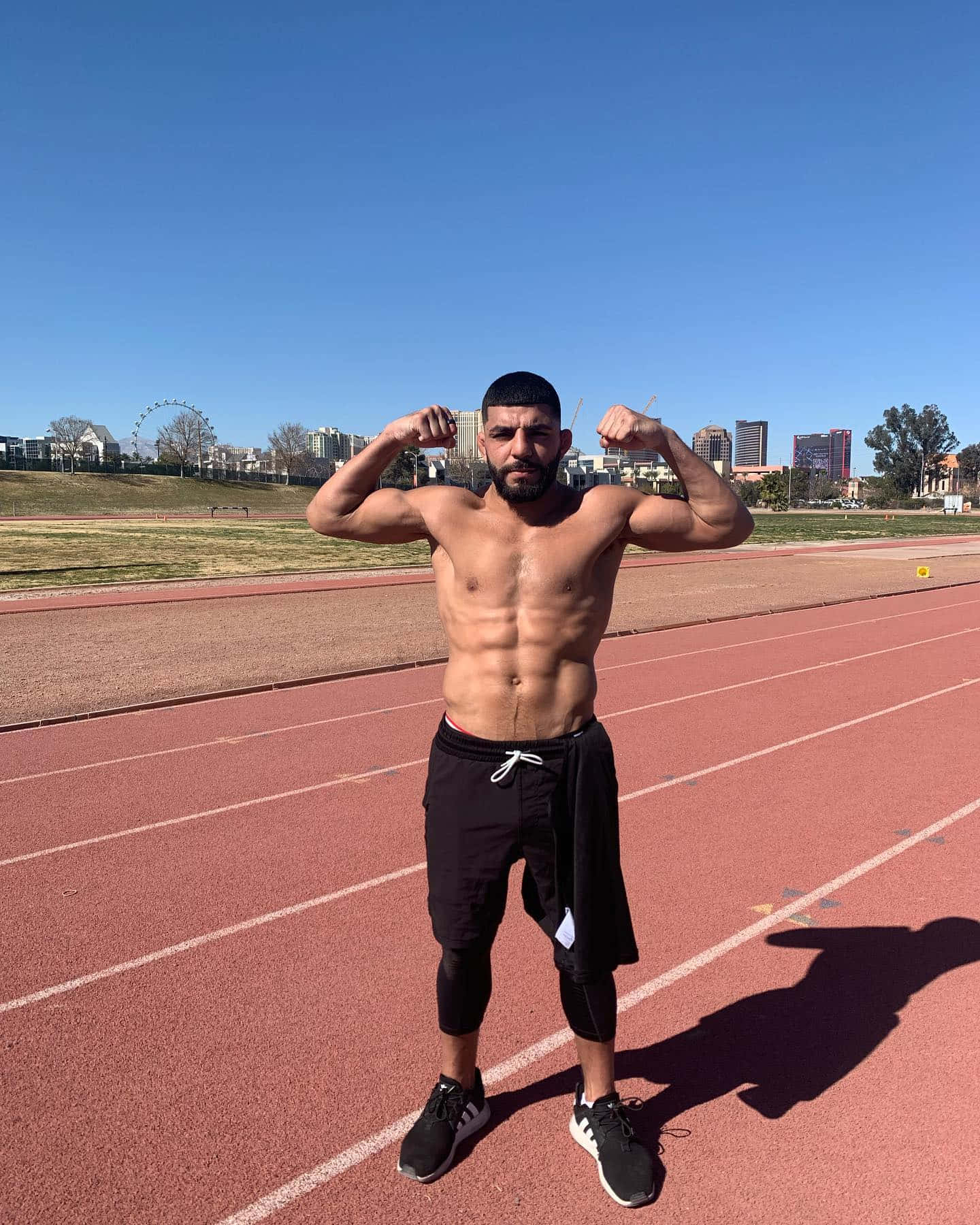 Amir Albazi Posing On Racetrack Wallpaper